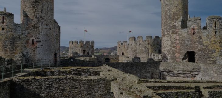 Medieval towers and stone walls of Conwy Castle under a dramatic sky