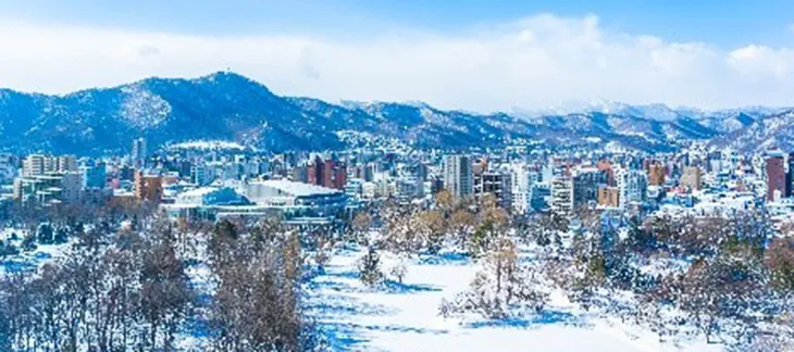 Snow-covered Sapporo cityscape with mountains in the background