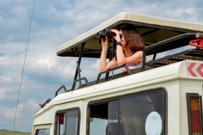 Arooha guest woman tourist on safari in Africa, travel in Kenya