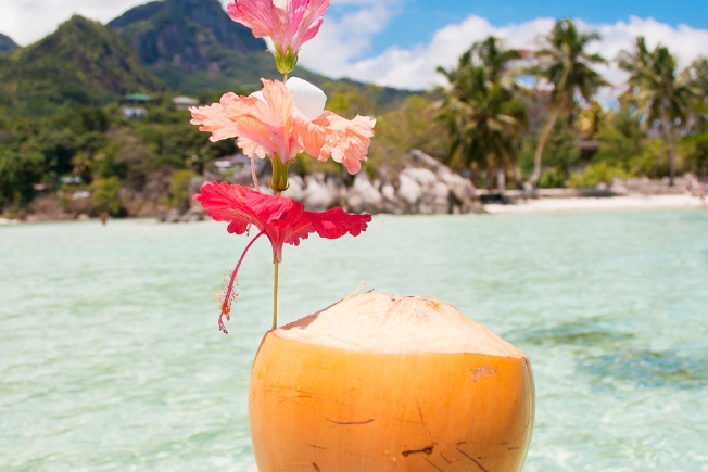 Arooha guest couple enjoying coconut during Seychelles tour packages from Dubai