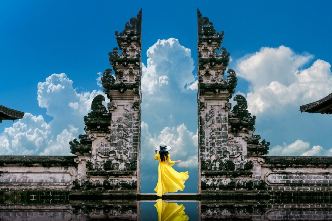 Arooha guest standing in temple gates at Lempuyang Luhur temple in Bali, Indonesia