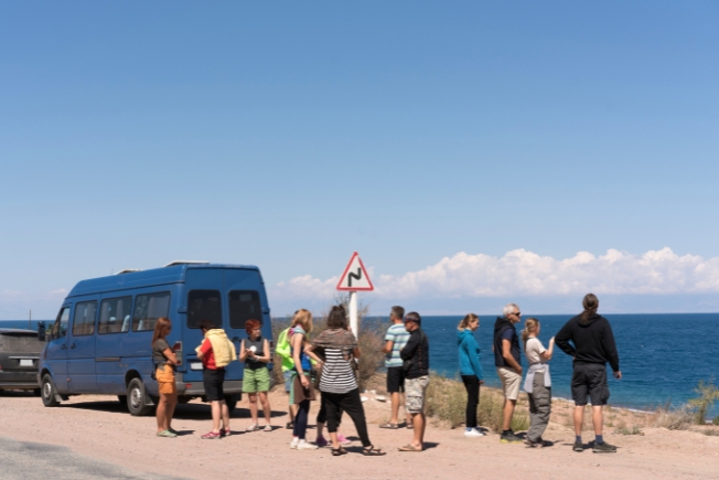 Arooha guest tourists at viewpoint of Lake Issy-kul in Kyrgyzstan