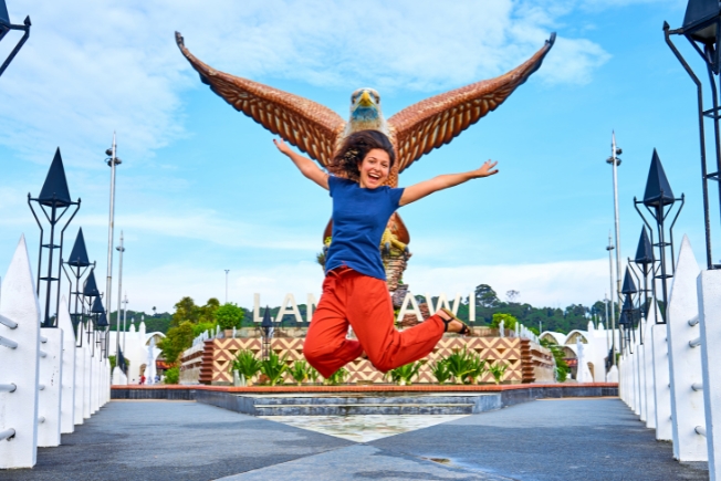 Arooha female tourist posing next to an Eagle Sculpture in Langkawi