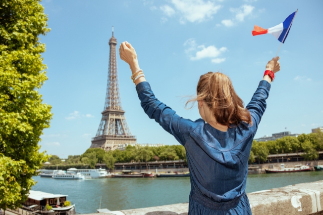 Arooha guest tourist with France flag rejoicing at Paris during France tour packages from Dubai