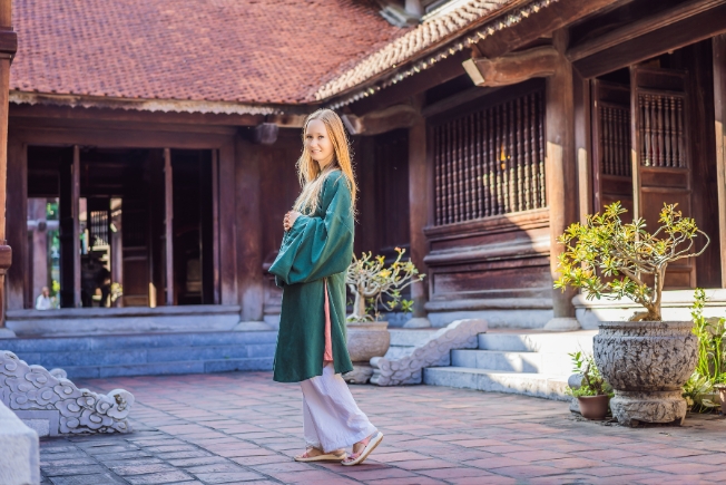 Arooha guest woman tourist in temple of Literature in Hanoi, Vietnam