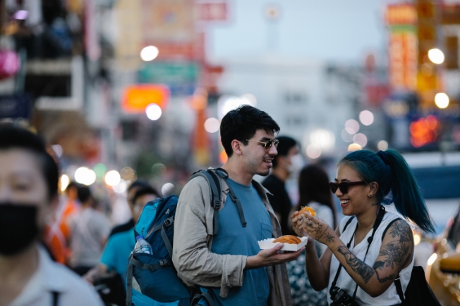 Arooha tourist eating street food during USA tour packages from Dubai