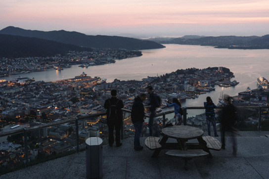 Group of Arooha Travelers overlooking Bergen city from a mountaintop at sunset
